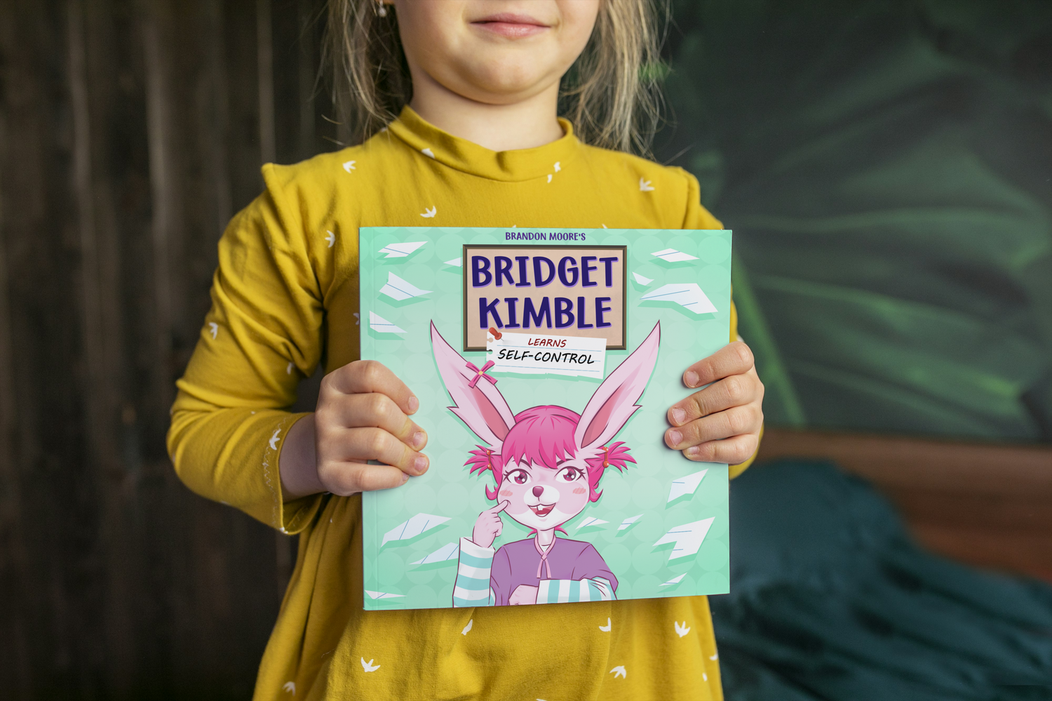 A Little Girl Holding a Childrens book called Bridget Kimble Learns Self-control